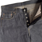 Closeup of HFD-01 Japanese selvedge denim relaxed fit wide leg jeans showing the button fly, waistband, rivets, and front pockets.