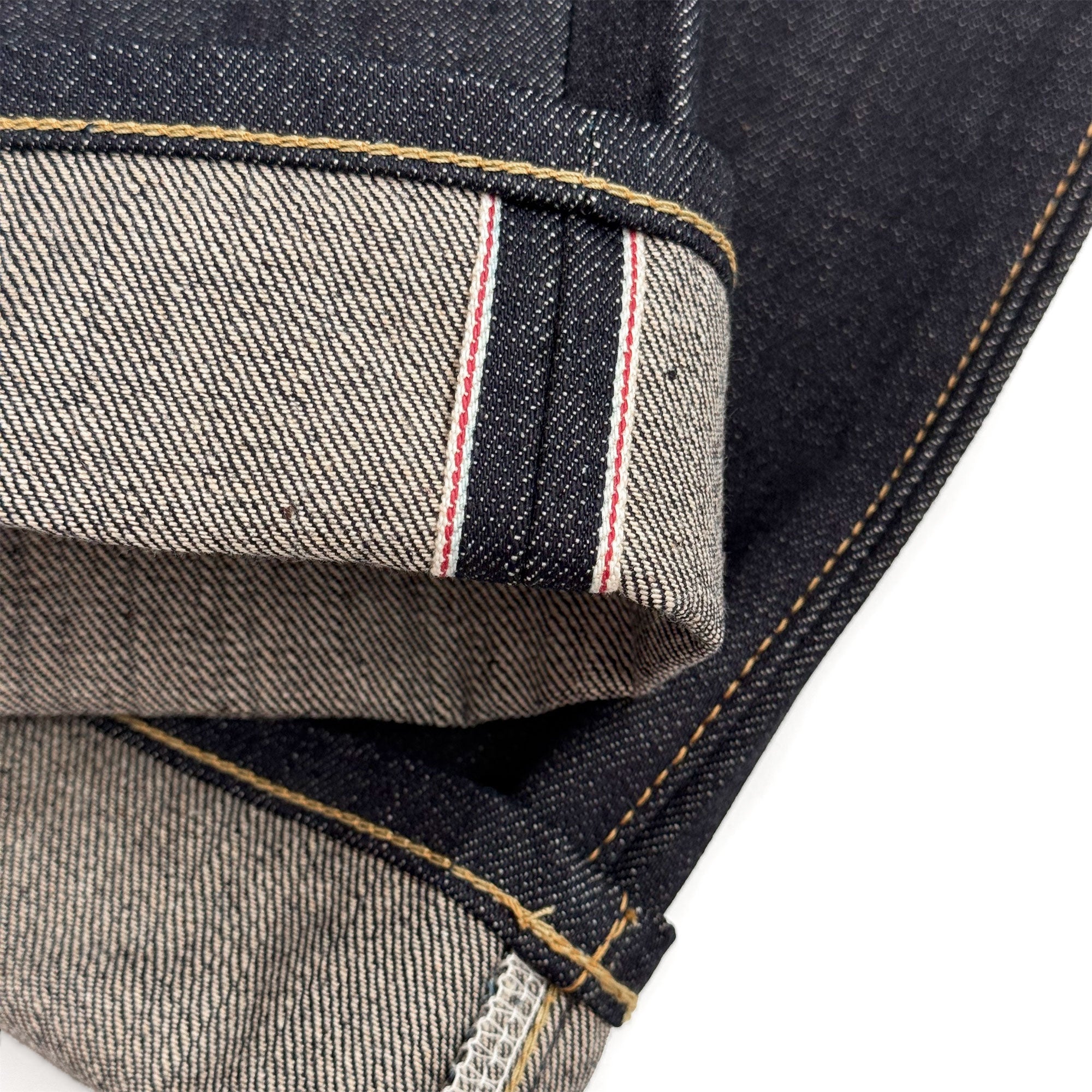 Closeup of the HFD02 redline selvedge ID and vintage-style chain stitched hem of Japanese selvedge denim relaxed fit tight tapered leg jeans.