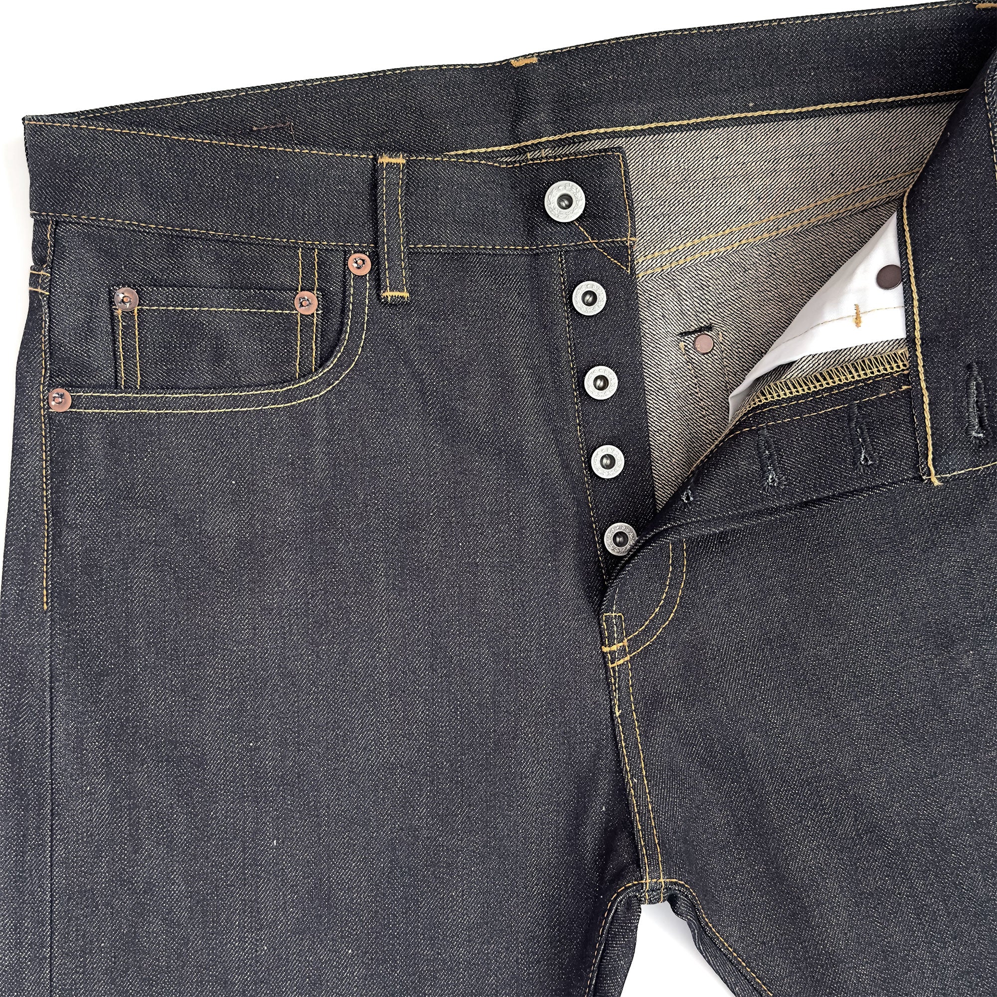 Closeup of HFD03 Japanese selvedge denim regular fit slim leg jeans showing the button fly, waistband, rivets, and front pockets.