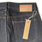 Closeup of the HFD04 jacron paper patch and kraft paper hangtag with logo on Japanese selvedge denim slim fit straight leg jeans.