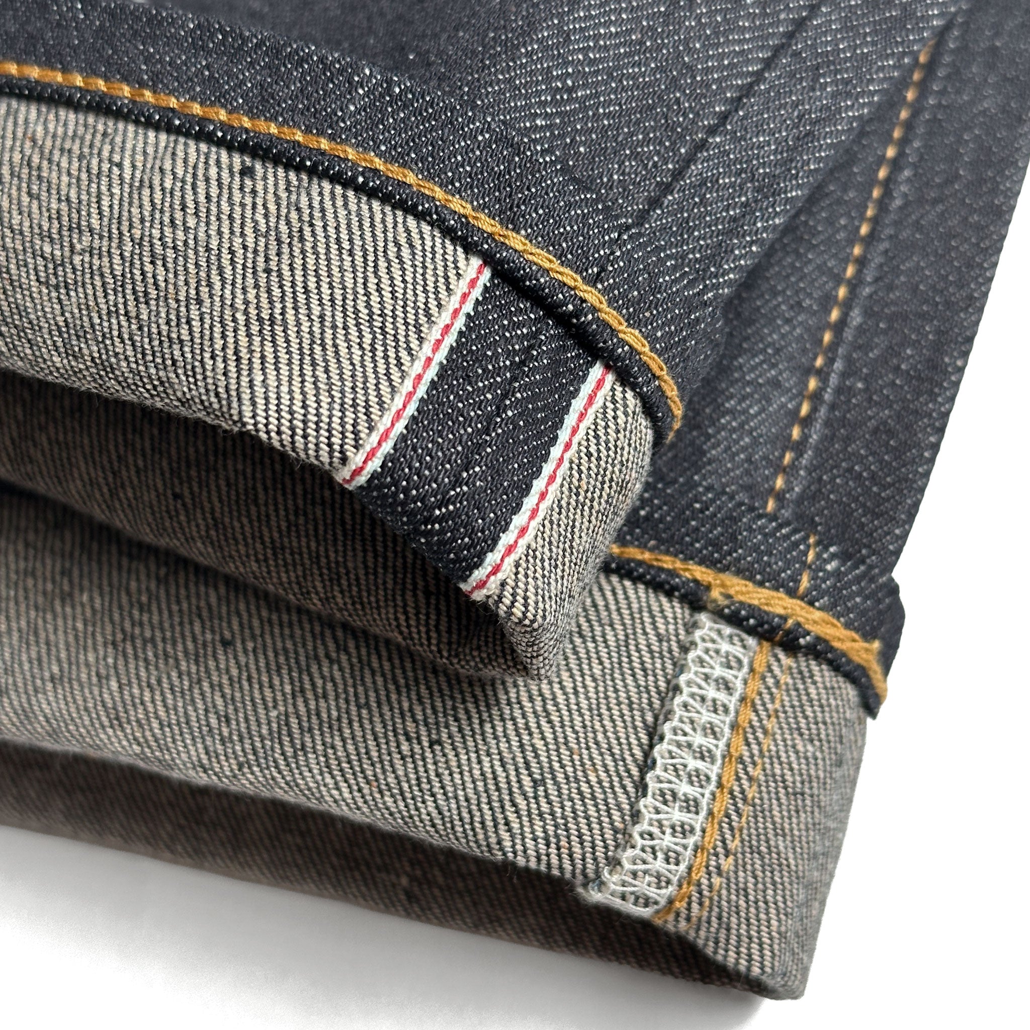 Closeup of the HFD04 redline selvedge ID and vintage-style chain stitched hem of Japanese selvedge denim slim fit straight leg jeans.