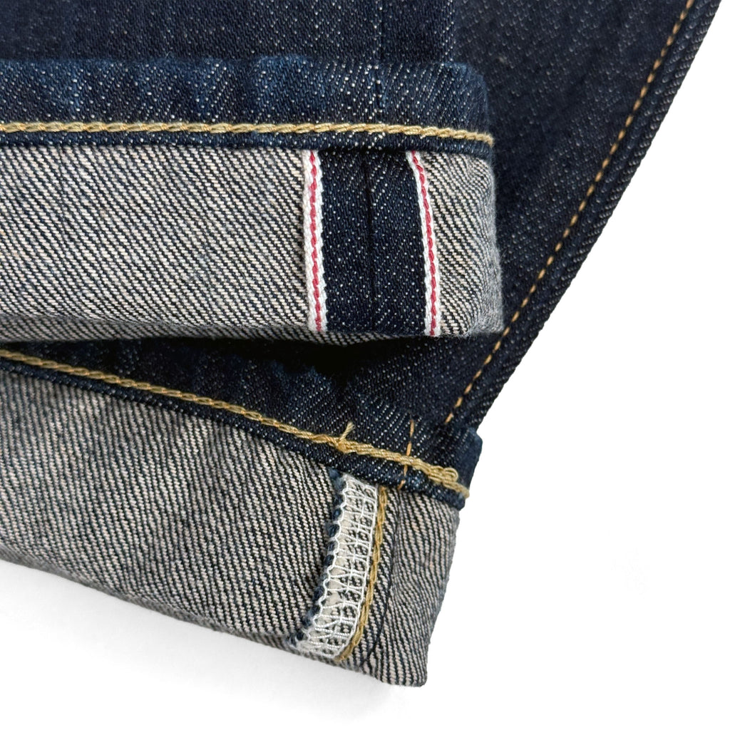 Closeup of the HFD-02 redline selvedge ID on the hem of Japanese selvedge denim  once washed relaxed fit tight tapered leg jeans.